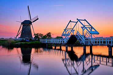 Netherlands rural landscape with windmills and bridge at famous tourist site Kinderdijk in Holland in twilight