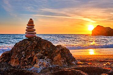 Concept of balance and harmony, Cairn stack of stones pebbles cairn on the beach coast of the sea in the nature on sunset, Meditative art of stone stacking