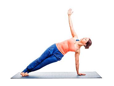 Beautiful sporty fit woman practices yoga asana Vasisthasana, side plank pose isolated on white