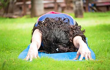 Close up of girl doing stretching yoga, girl doing bharata yoga, young woman doing stretching yoga outdoors