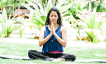 A girl sitting doing meditation yoga outdoors, Woman doing yoga outdoors, a young woman doing yoga with closed eyes