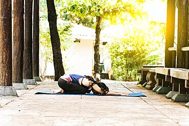 Woman doing yoga child's pose, girl doing yoga child's pose