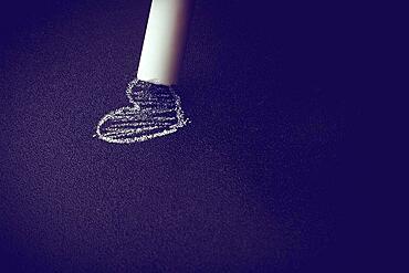 Hand holding white chalk and black board