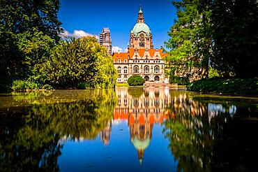 The new city hall of Hannover with the Maschpark and the Maschteich in the foreground with reflection in the water, in sunshine, blue sky and scattered clouds, Hannover, Lower Saxony, Germany, Europe