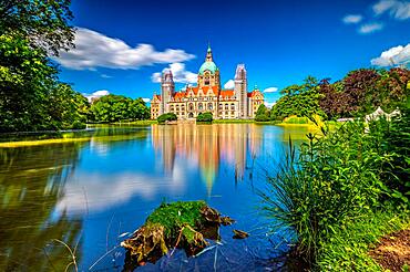 The new city hall of Hannover with the Maschpark and the Maschteich in the foreground with reflection in the water, in sunshine, blue sky and scattered clouds, Hannover, Lower Saxony, Germany, Europe