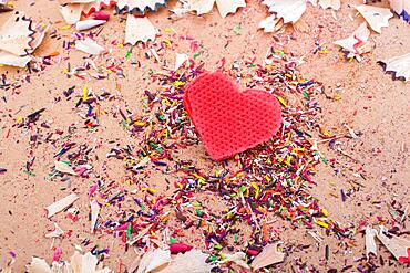 Heart shaped object amid pencil shavings