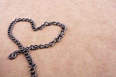 Chain form a heart shape on a brown background