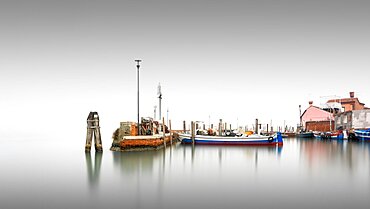 Classic harbour view of the small port of Burano in the fog in Italy