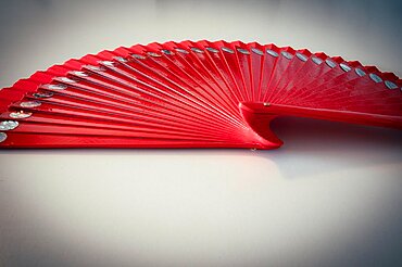 Red fan made of wood with sequins on white background, Hanover, Lower Saxony, Germany, Europe