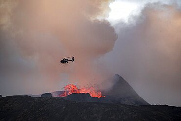 Helicopter flying over smoking active volcanic crater, glowing lava, volcanic eruption, active table volcano Fagradalsfjall, Krysuvik volcanic system, Reykjanes Peninsula, Iceland, Europe