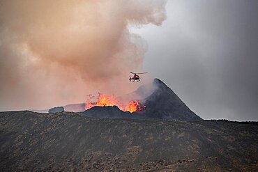 Helicopter flying over smoking active volcanic crater, glowing lava, volcanic eruption, active table volcano Fagradalsfjall, Krysuvik volcanic system, Reykjanes Peninsula, Iceland, Europe