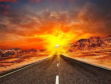 Travel forward concept background, road in Himalayas with mountains and dramatic clouds on sunset. Ladakh, Jammu and Kashmir, India, Asia