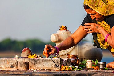 MAHESHWAR, INDIA, APRIL 26: Indian woman performs morning pooja on sacred river Narmada ghats on April 26, 2011 in Maheshwar, Madhya Pradesh, India. To Hindus Narmada is one of 5 holy rivers of India