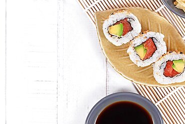 Sushi inside out rolls with salmon, avocado and sesame on small leaf shaped plateSushi inside out rolls with salmon, avocado and sesame on small leaf shaped plate