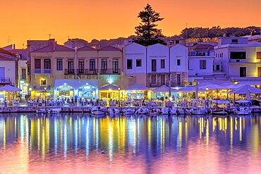 Venetian harbour, dusk, night shots, orange sky, colourful rows of houses, boats, water reflection, artificial light, Rethimnon, central Crete, island of Crete, Greece, Europe