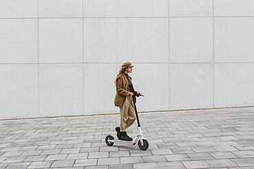 young woman riding electric scooter