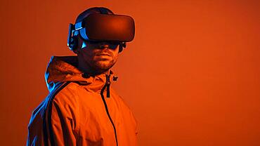 man wearing virtual reality gadget with orange light