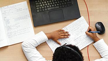 Boy doing homework with use laptop