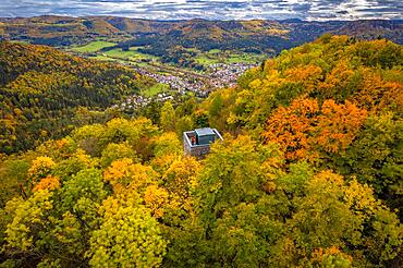 Man in red on tower in autumn forest, Swabian Alb, Germany, Europe