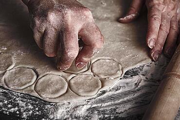 Cooking dough by elderly woman cook hands for homemade pastry dumplings on table background