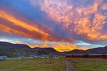 Dramatic sunset over small cabins at a campsite, Honningsvag, Finnmark, Norway, Europe