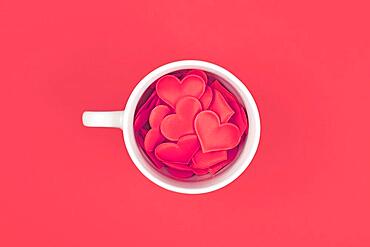 Top view of tea cup filled with red hearts