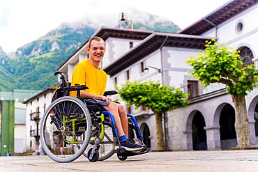 Portrait of a disabled person in a wheelchair walking through the town square