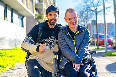 Portrait of a disabled person in a wheelchair with a friend, normality of disabled people
