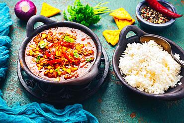 Hot Mexican Chili con carne with rice and tortilla chips and spices