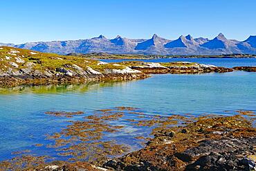 Small bay and view of the Seven Sisters Mountains, Heroey Island, Kystriksveien, Nordland, Norway, Europe