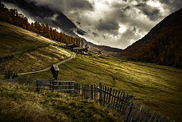 Alpine hut in autumnal mountain landscape with threatening cloudy sky, Pfossental, Merano, Vinschgau, South Tyrol, Italy, Europe