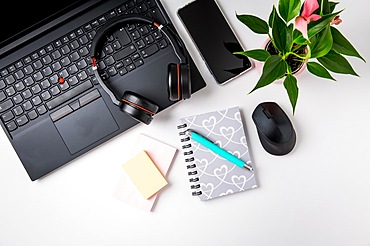 Workplace and office desk with laptop, headset and smarthpone. Flatlay on white background