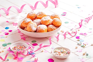 Krapfen, Berliner and donuts with streamers and confetti. Colorful carnival, birthday and Fasching image