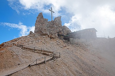 A closed mountain shelter in the Dolomites with a cross towering over it. Dolomites, Italy, Dolomites, Italy, Europe