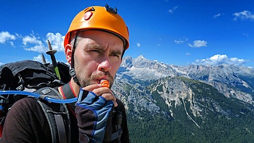 A thirsty tourist drinks water through a tube against the backdrop of an amazing panorama of the mountains in the Dolomites. Dolomites, Italy, Dolomites, Italy, Europe