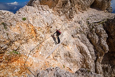 Tourist crossing the via ferrata trail with equipment in the dolomites. Dolomites, Italy, Dolomites, Italy, Europe