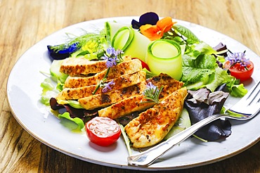 Roasted chicken breast with summer salad served on a plate