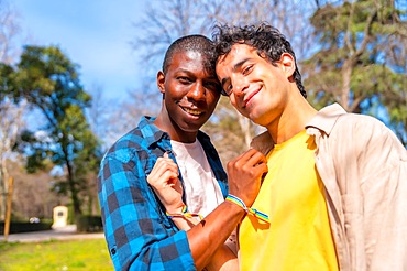 Portrait of multiethnic gay male couple on a romantic walk in the park, lgbt concept