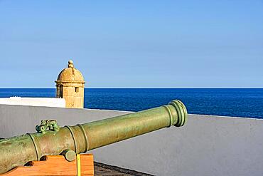 Old iron cannon and guardhouse on the strong walls of the historic fortress of Farol da Barra in the city of Salvador, Bahia, Brasil