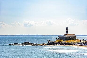 Barra beach and lighthouse seen from afar with the summer sun of Salvador in Bahia, Brasil