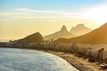 Golden sunset between Copacabana buildings and hills, Praia de Copacabana, Rio de Janeiro, Rio de Janeiro, Brasil