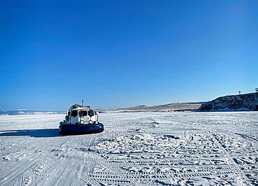 Khivus winter transport on ice. Hovercraft. Ice on the surface of the transparent frozen Lake Baikal. Blue sky. Horizon. Horizontal. Baikal in winter