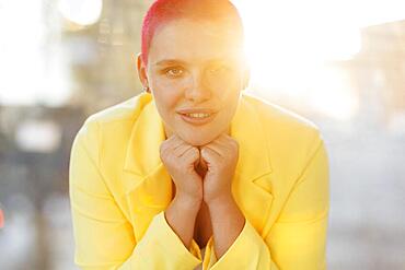 Beautiful relaxed woman in yellow suit and red shot hair while resting on sunny weekend day at home. Body positive concept