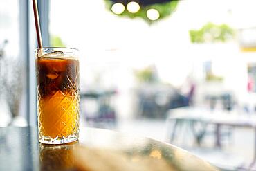 Iced coffee with orange. Glass of americano mixed with craft soda and yuzu orange juice on blurred background, Refreshing summer drink concept