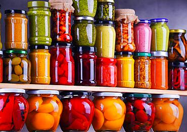 Jars with variety of pickled vegetables and fruits. Preserved food