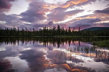 Dramatic sunset by the river Namsen with reflection, Namsskogan, Trondelag, Norway, Europe