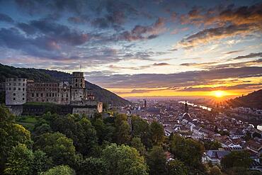 The city of Heidelberg at sunset during the golden hour, the castle in the foreground, the old town and the river Neckar in the background. Baden-Wuerttemberg, Germany, Europe