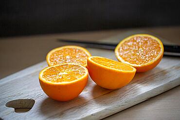 Delicious juicy oranges lie sliced on a wooden board