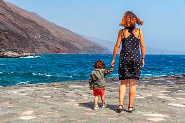 Mother and son on vacation in summer at the pier of Orchilla on the southwest coast of El Hierro. Canary Islands