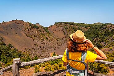 A young tourist with a hat at the viewpoint of the Fireba volcano in La Llania park in El Hierro, Canary Islands